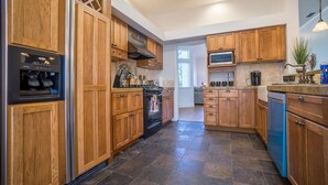 A modern kitchen with wooden cabinets, a built-in oven, and a dishwasher.