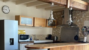 A kitchen with a wooden island, a refrigerator, a microwave, and a sink. - Private gite for rent in a wine estate (Sigoulès)