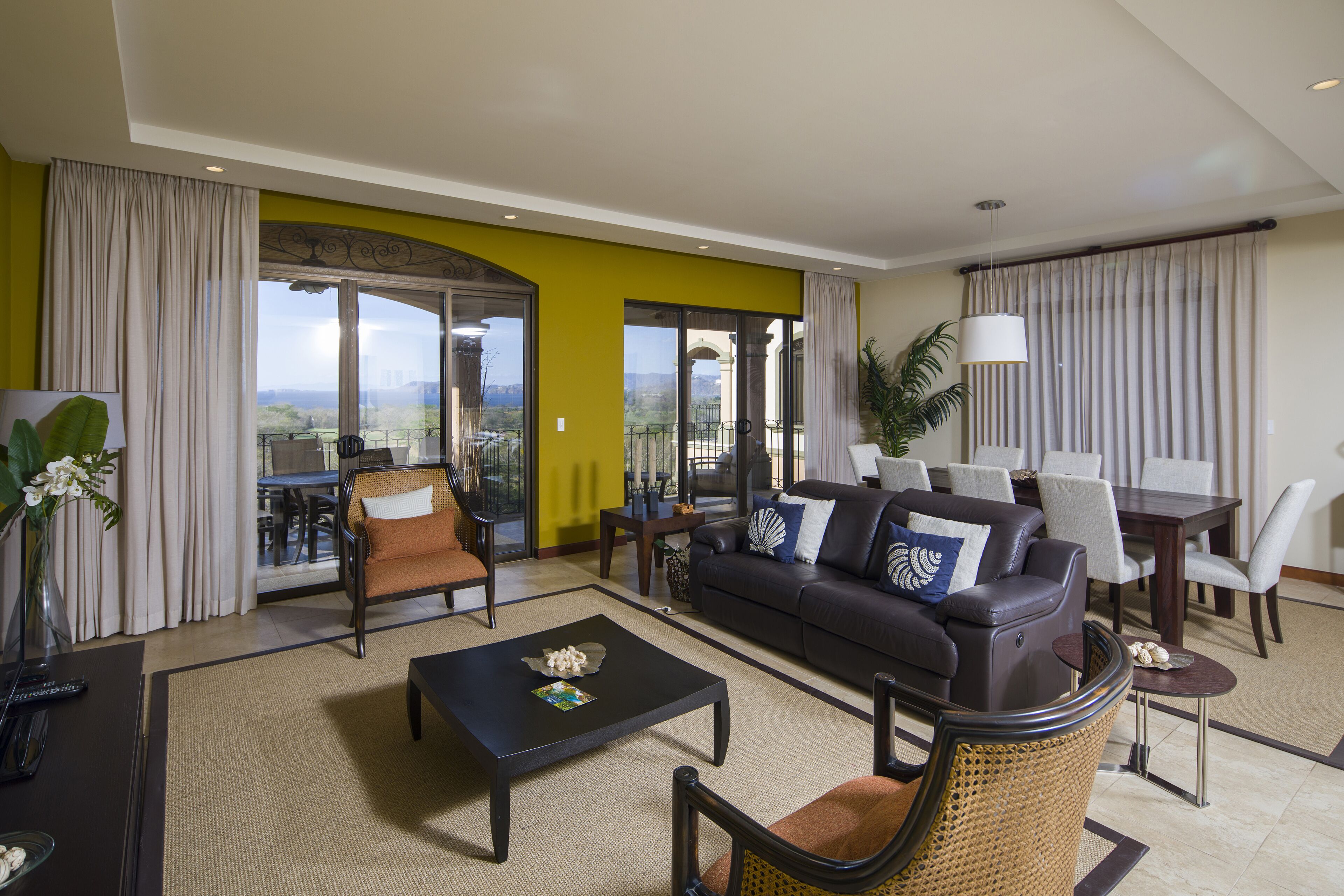 A spacious living room with a sofa, chairs, a coffee table, and a dining area.