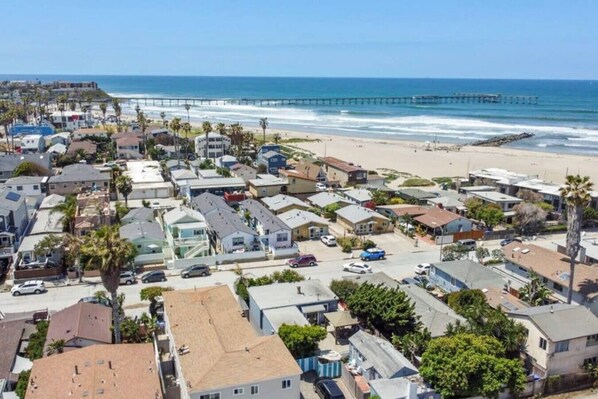 Une zone résidentielle côtière comprenant des maisons, une plage et une jetée.