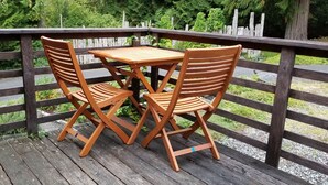 Une terrasse en bois avec une table et deux chaises.