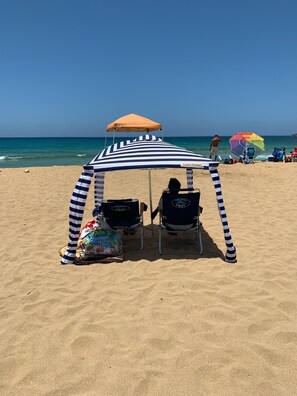 A beach with a striped canopy tent and two beach chairs labeled "Relax". - Arecibo, Puerto Rico (Playa Islote) (Arecibo)