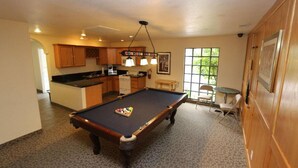 A pool table in a room with a kitchen area, a dining table, and a window with a view. - 2 bed condo Thunderbird Resort Club - Sparks (Sparks)