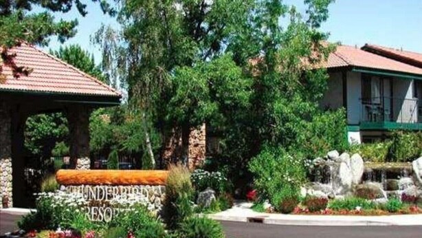 A building with a sign reading "THUNDERBIRD RESORT" surrounded by lush greenery and a paved area. - 2 bed condo Thunderbird Resort Club - Sparks (Sparks)