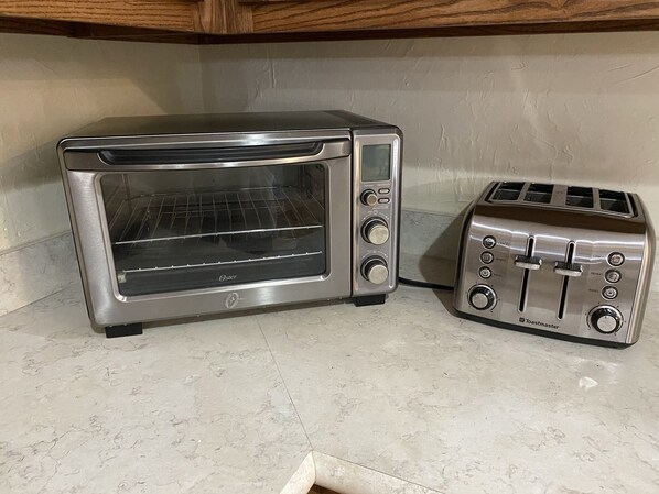 A kitchen with a built-in toaster oven and a separate toaster.