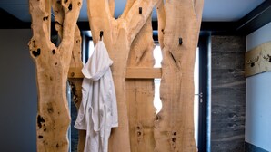 Une structure en bois, en forme d’arbre, avec une serviette suspendue à l’une de ses branches.