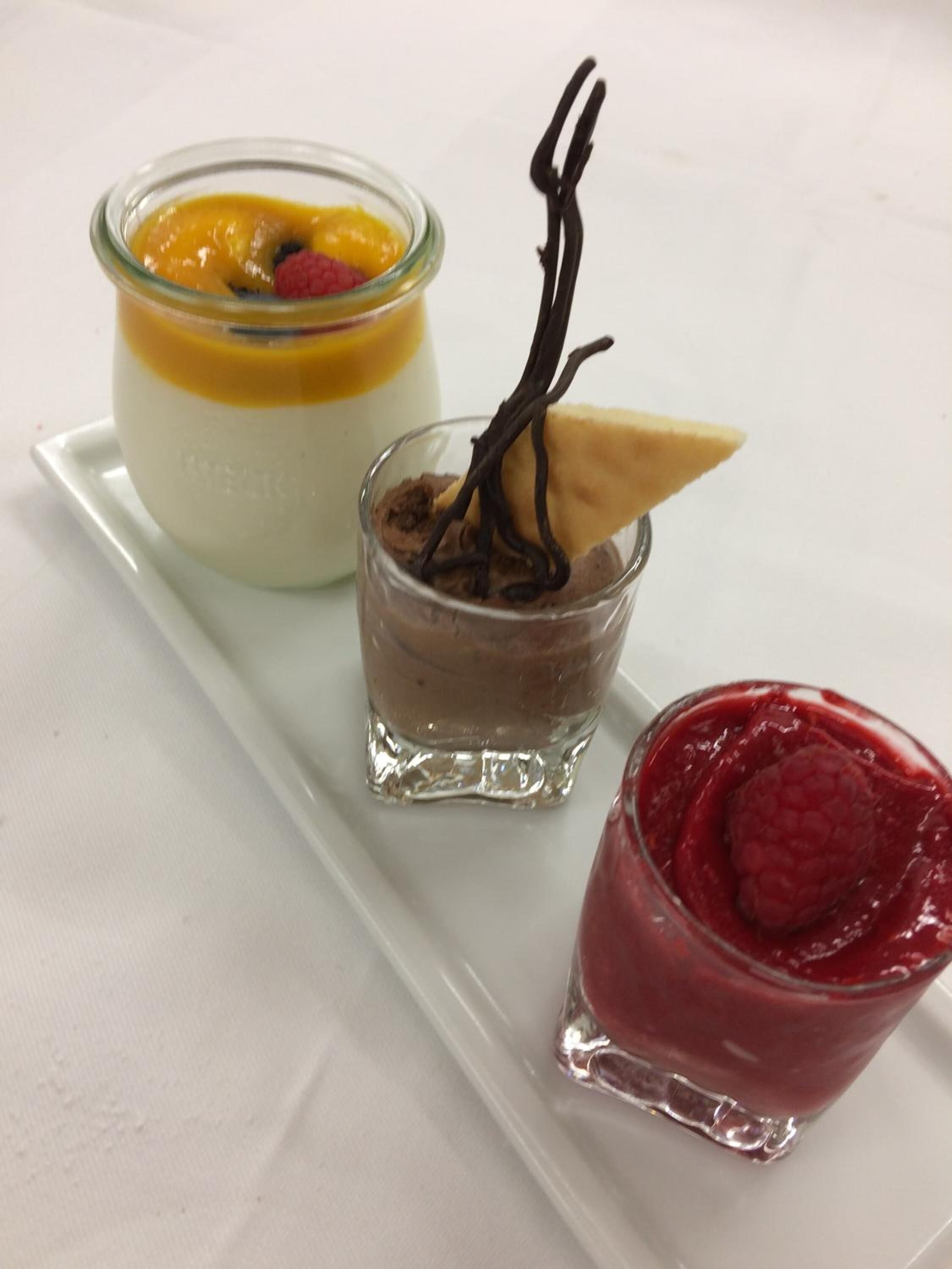 Three dessert dishes on a white rectangular plate.