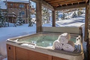 Una cabaña de madera con un jacuzzi y toallas.