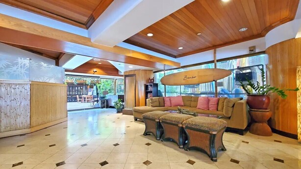 A spacious lobby with a wooden ceiling, a large sofa with cushions, and a bamboo umbrella. - 🌤Stay in our Breezy Bamboo Studio 🏘Now this is what we call home! 2QUEEN Beds (Honolulu)