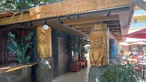 A courtyard with wooden carvings, potted plants, and outdoor seating. - 🌤Stay in our Breezy Bamboo Studio 🏘Now this is what we call home! 2QUEEN Beds (Honolulu)