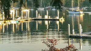 A marina with boats docked, calm water, and a dock with a small pier. - Eagle Harbor View Cottage (Bainbridge Island)