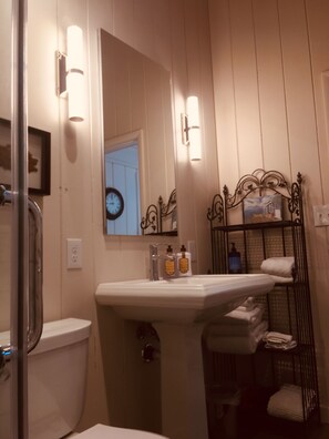 Une salle de bain avec un lavabo, un miroir et un porte-serviettes.