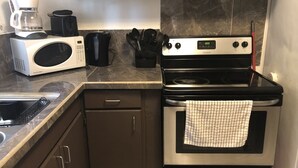 A compact kitchen with a microwave, coffee maker, and stove. - PEDRO'S PLACE PRIVATE APARTMENT 2 BDRM 1 ba Free Power, Water and Internet (Sinajana)