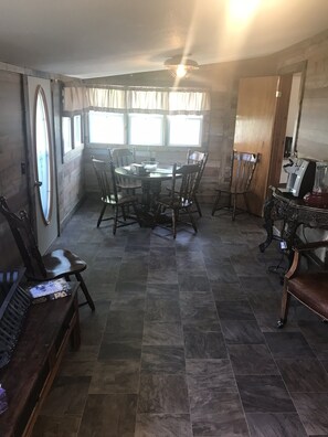 A dining area with a round table and chairs, a wooden bench, and a blender on a counter. - Blue Sky Homestead!! (Bethany)