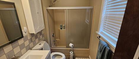 Un baño con inodoro, lavamanos y ducha.