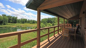 Eine Holzterrasse mit Blick auf einen See und Bäume.