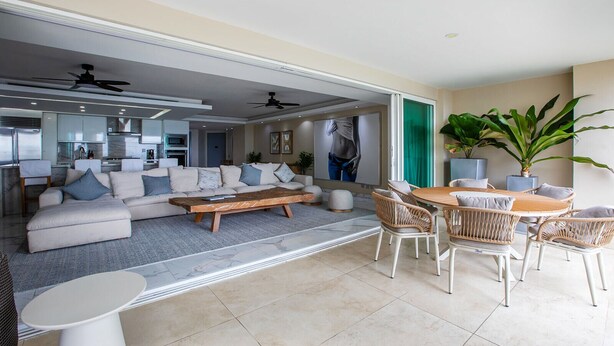 A spacious living area with a sofa set, a wooden coffee table, and wicker chairs. - Gorgeous condo at Marina area , great views , luxury layout, jacuzzi,beach front (Puerto Vallarta)