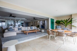 A spacious living area with a sofa set, a wooden coffee table, and wicker chairs. - Gorgeous condo at Marina area , great views , luxury layout, jacuzzi,beach front (Puerto Vallarta)