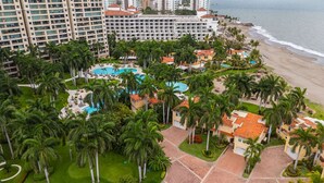 Un resort con varias edificaciones, una piscina y una playa.