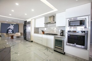 A modern kitchen with stainless steel appliances, marble countertops, and a minimalist design. - Gorgeous condo at Marina area , great views , luxury layout, jacuzzi,beach front (Puerto Vallarta)