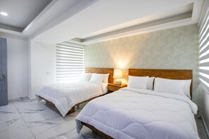 A hotel room with two beds, a wooden headboard, a nightstand with a lamp, and a door. - Gorgeous condo at Marina area , great views , luxury layout, jacuzzi,beach front (Puerto Vallarta)