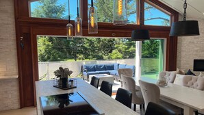 Una cocina moderna con una isla central, ventanas amplias y un comedor con vistas al exterior.