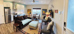 A compact living space with a kitchenette, a sofa, a dining area, and a patterned rug.