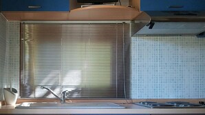 A kitchen with a sink, stove, and blue cabinets. - Camping Amalasunta (Montefiascone)
