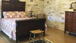 Ein Schlafzimmer mit Bett, Schminktisch, Nachttisch und Lampe.