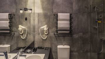 Un bagno moderno con una vasca da bagno ampia, un water e una doccia.