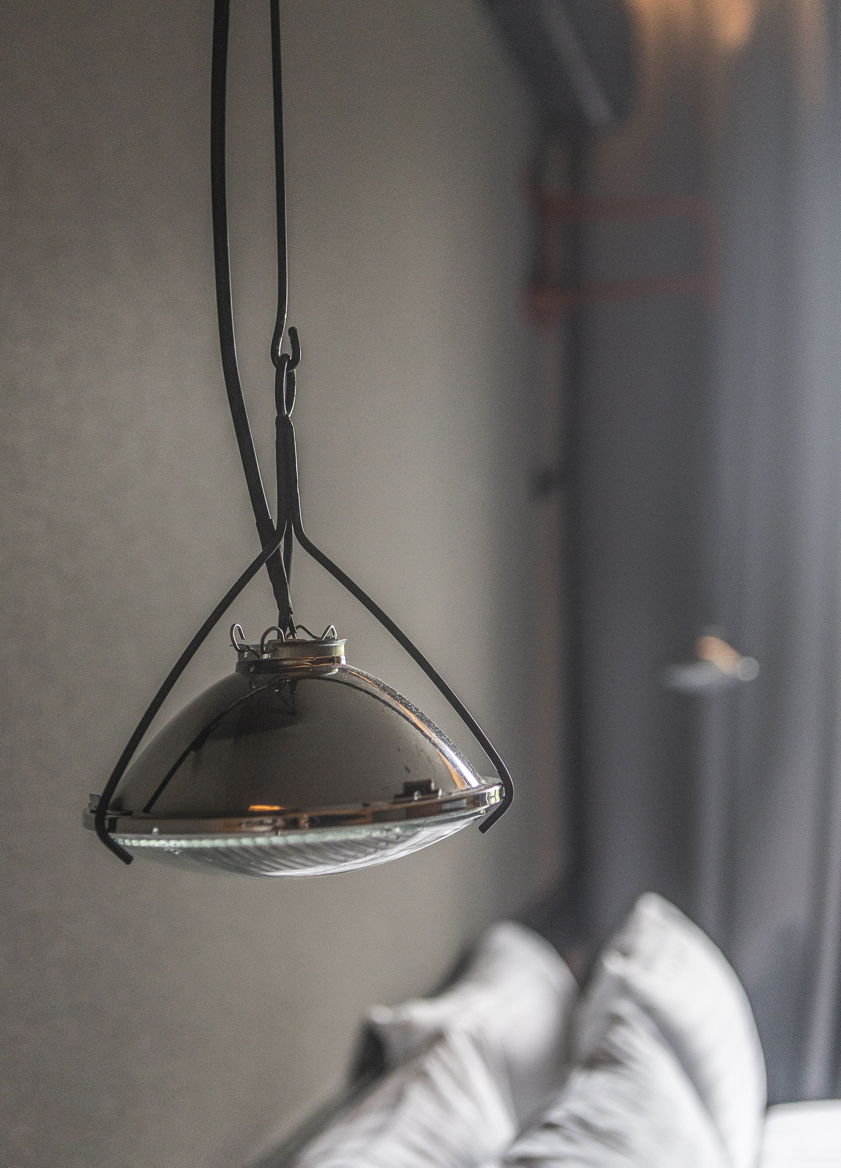 A pendant light fixture with a clear glass shade and a metal frame, hanging from a black cord.