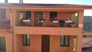 A two-story building with balconies, windows, and a door. - B&B Tatti (Nughedu Santa Vittoria)