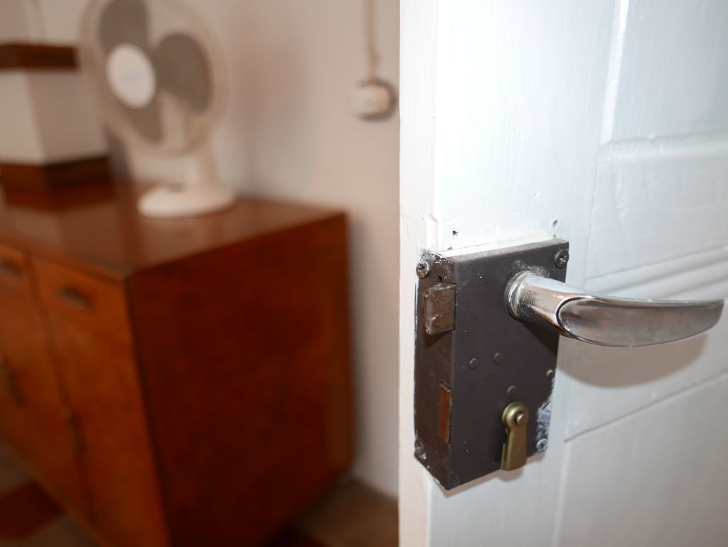 A white door with a metal handle and a keyhole.