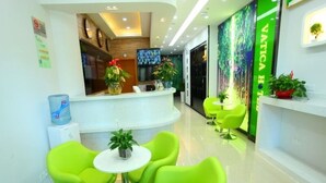 A modern reception area with bright green chairs and a white reception desk. - Vatica Beijing Chaoyang West Dawang Rd Jiulongshan Metro Station Hotel (Beijing)