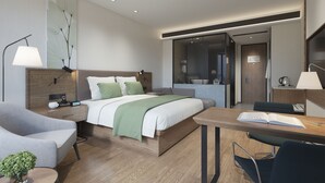 Una habitación de hotel moderna con una cama, una mesita de noche, una lámpara y un escritorio con una silla.