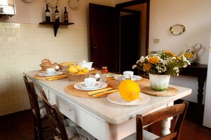 Mesa de desayuno con platos, tazas y un florero.