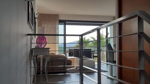 A modern living room with a sofa, a coffee table, and a decorative pink vase. - Luxury chalet: private pool, close to the beach, W-Lan incl., quiet location, village within walking distance  (Cala Mendia)
