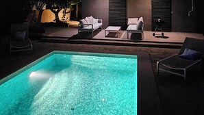 A modern two-story house with a swimming pool, outdoor seating, and a balcony with lights. - Luxury chalet: private pool, close to the beach, W-Lan incl., quiet location, village within walking distance  (Cala Mendia)