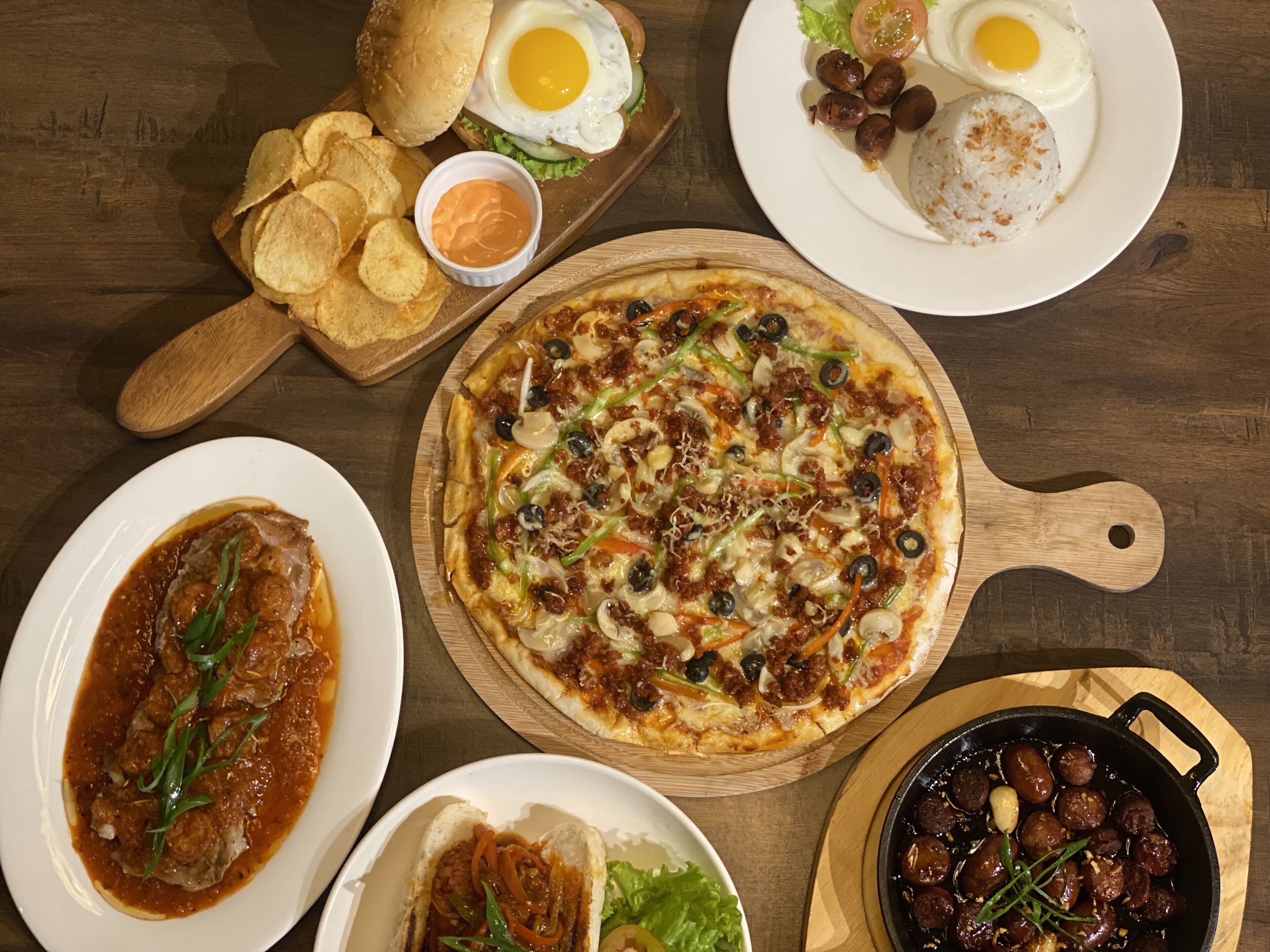 Variedad de platos, incluyendo pizza, un guiso de carne y un plato con huevos y arroz.