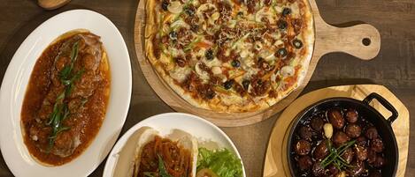 Variedad de platos, incluyendo pizza, un guiso de carne y un plato con huevos y arroz.