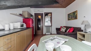 A compact living space with a kitchenette, a dining area, and a seating area with a couch and a table. - Italianway Easy - Bligny 19 C (Milan)