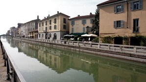 A canal with buildings on one side and a bridge on the other. - Italianway - Ripa Ticinese 17 (Milan)