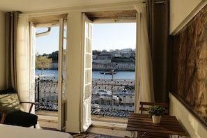 A room with a balcony overlooking a river and historic buildings. - Porto Tile House  (Porto)