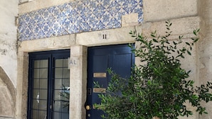 Un edificio con una puerta azul que lleva la etiqueta “AL” y el número “11” arriba.