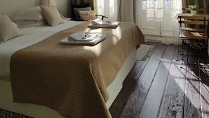 Una habitación de hotel con cama, escritorio y ventana con cortinas.