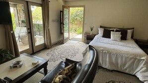 A hotel room with a bed, a sofa, a coffee table, and a TV.