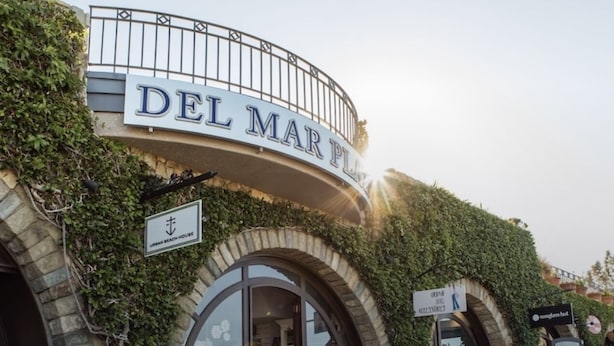A building named DEL MAR PL with a sign above the entrance.