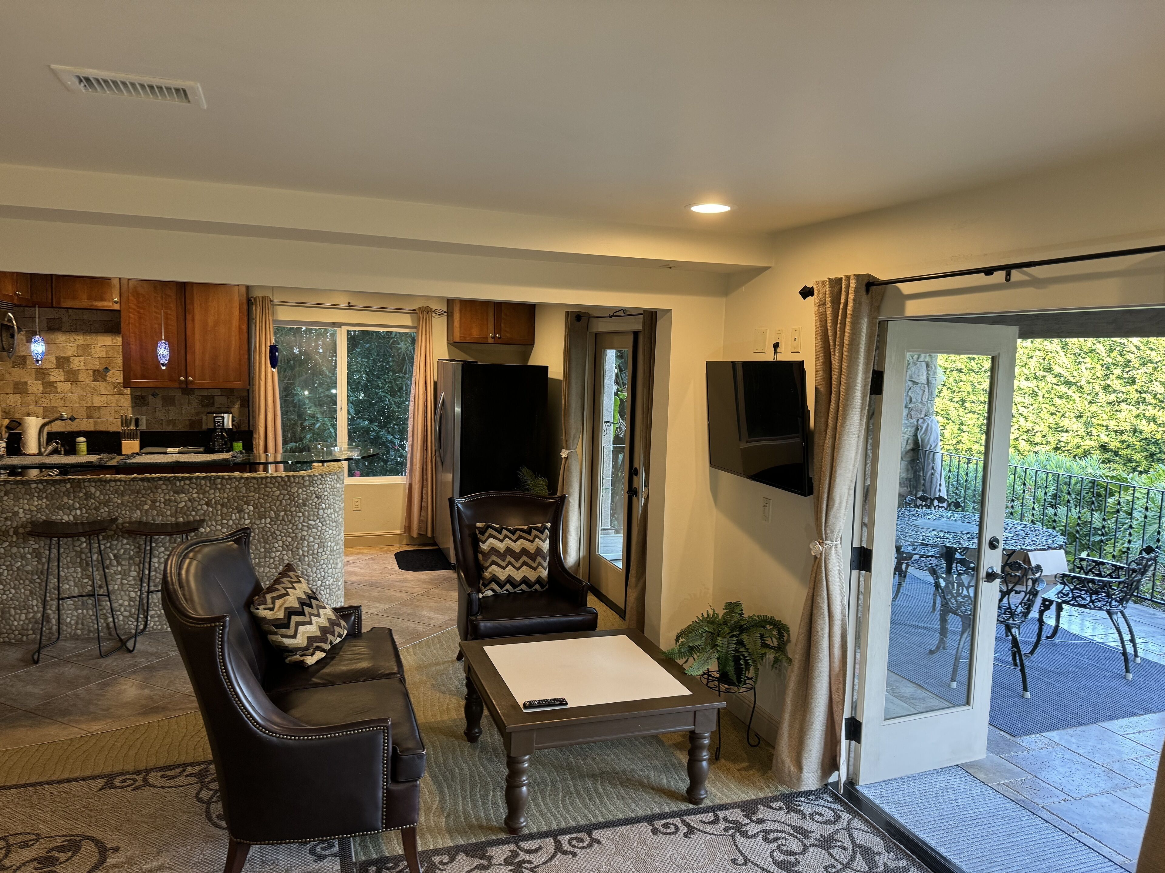 A spacious living area with a kitchen, a dining table, and a comfortable seating arrangement.
