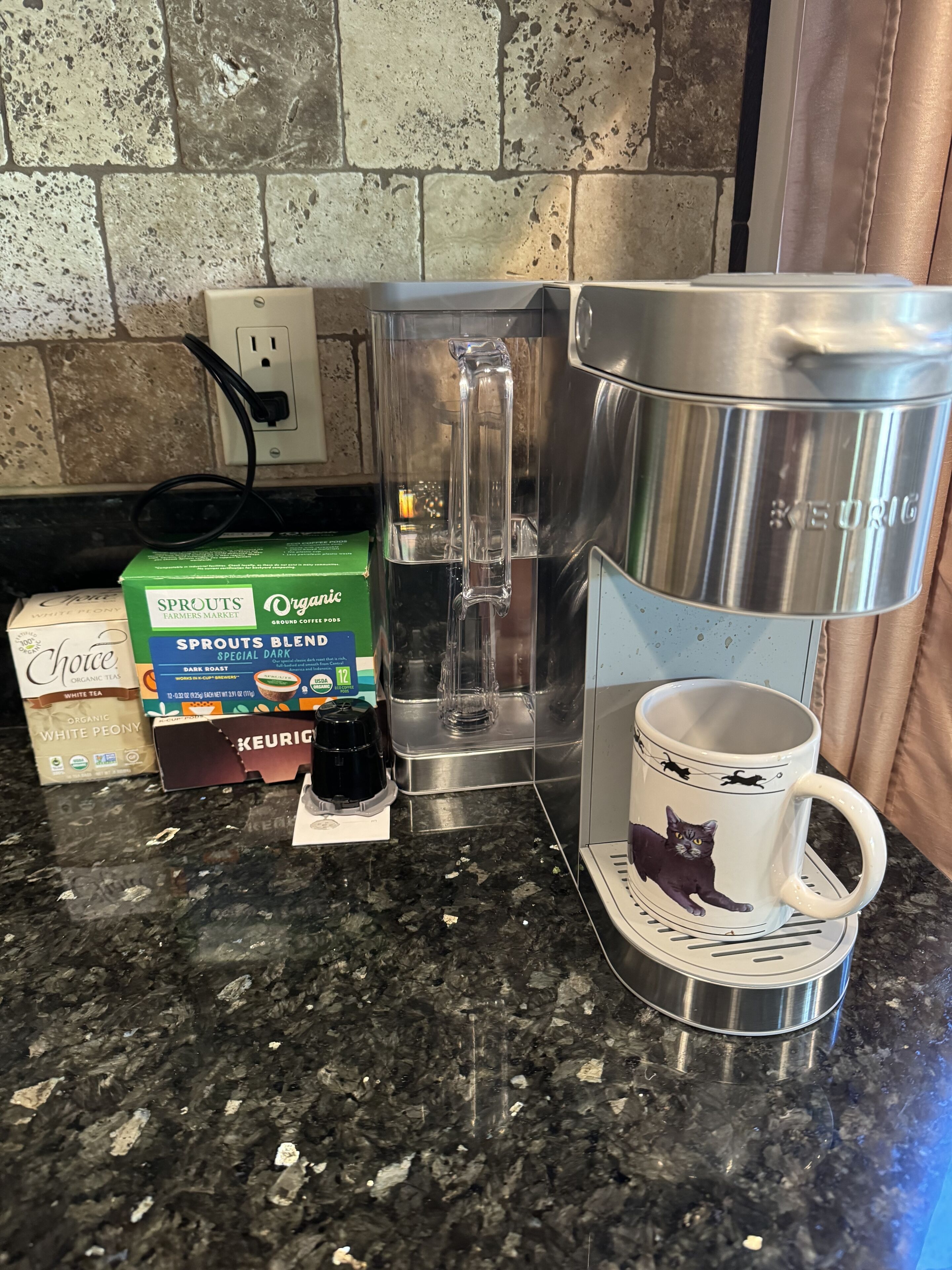 A kitchen counter with a coffee maker, a Keurig coffee pot, and coffee pods.