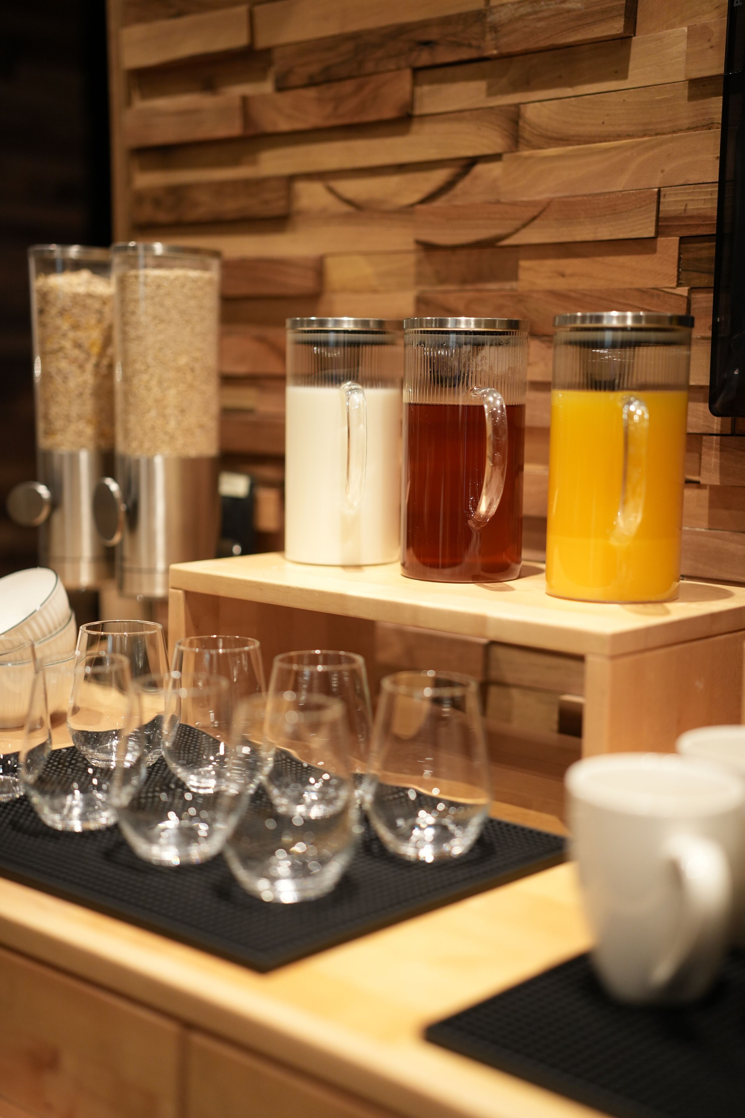 Um balcão de café da manhã com diversas bebidas e copos.